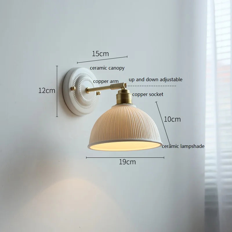 Wall lamp with round grooved ceramic shade and brass arm