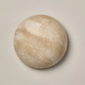 Round travertine wall light with warm backlighting in a natural stone look