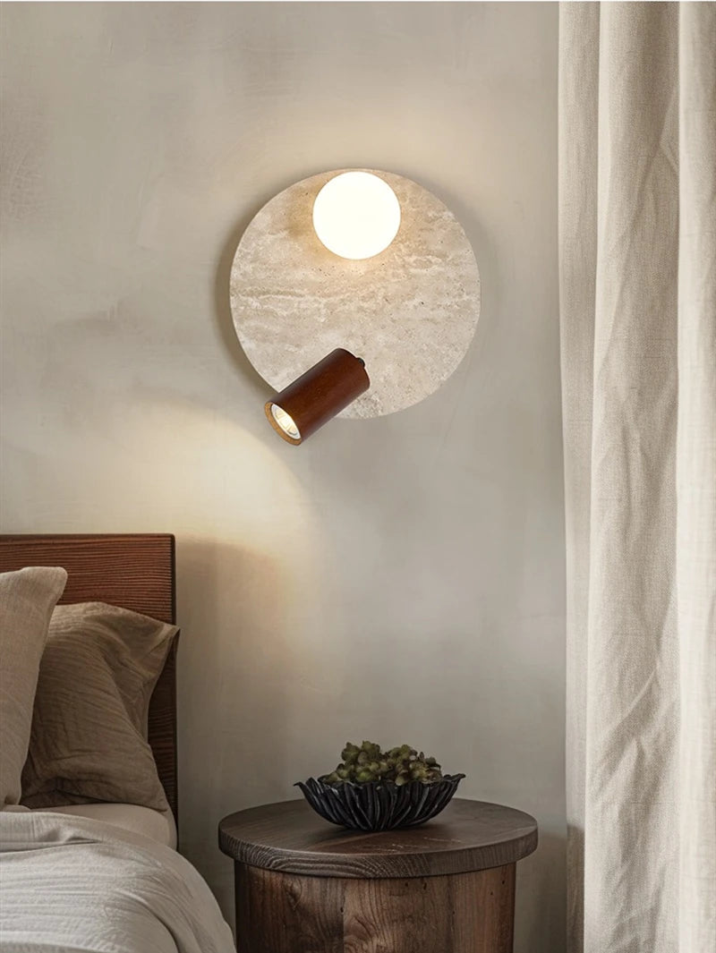 Large travertine wall light with spherical glass shade and warm wood spotlight