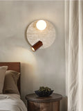 Large travertine wall light with spherical glass shade and warm wood spotlight