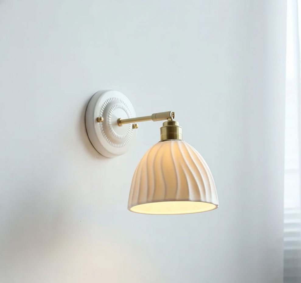 Wall lamp with grooved ceramic shade and brass arm