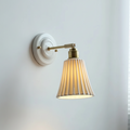 Wall lamp with long grooved ceramic shade and brass arm